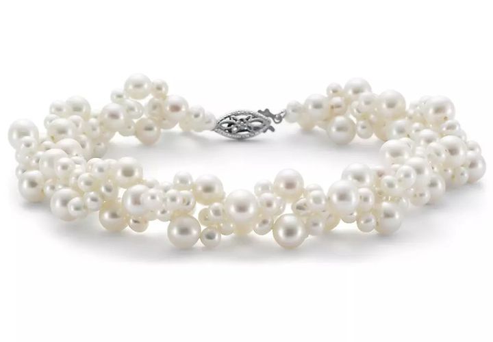 A woven pearl freshwater pearl bracelet made of clusters of various sizes and clasped with white filigree clasp